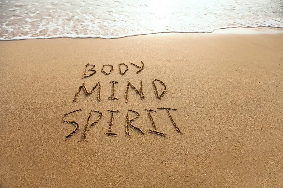 Scritta body mind spirit sulla sabbia simbolo di equilibrio e benessere psicofisico
