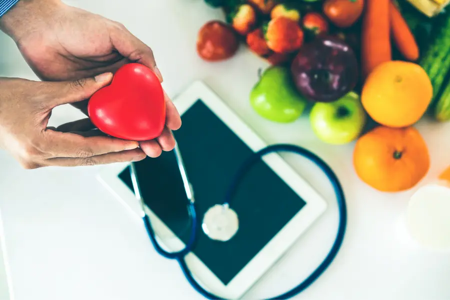 Alimentazione sana e sport con simbolo del cuore e frutta per il benessere