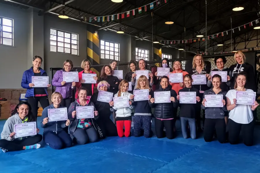 Partecipanti a corso di difesa personale mostrano attestati dopo allenamento in palestra