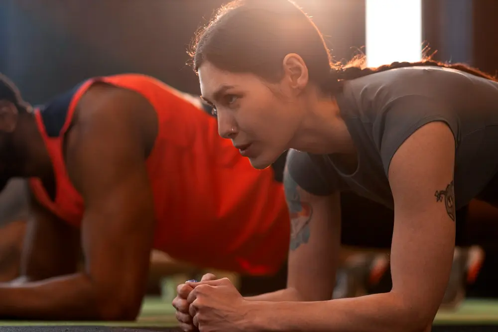 Persone durante esercizio plank in allenamento fitness per migliorare forza e motivazione
