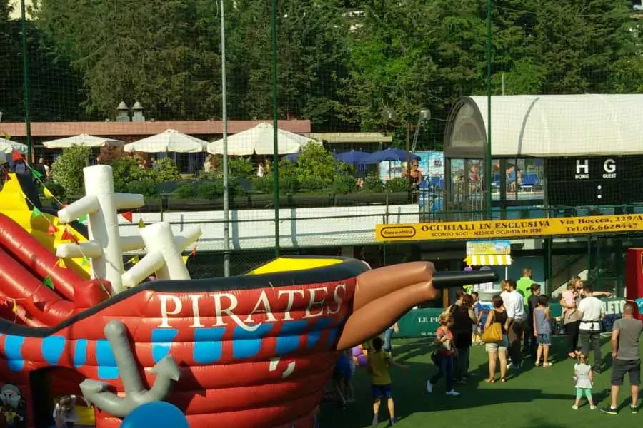 Bambini e famiglie durante evento sportivo con gonfiabili e attività ludiche all’aperto