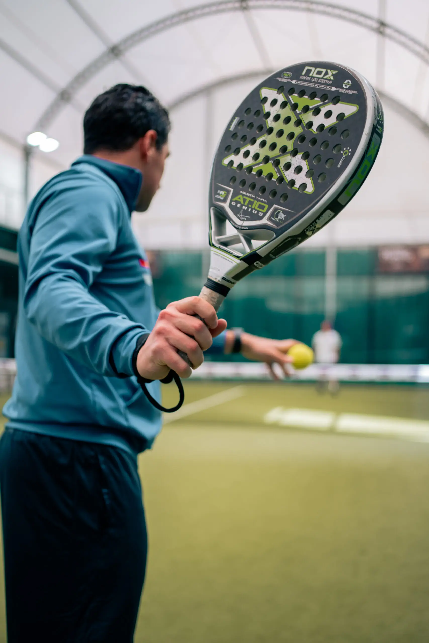 giocatore che prepara servizio a padel durante partita